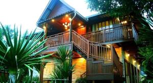 een huis met een trap en verlichting bij Baan Saranrom in Amphawa