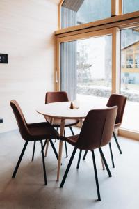 une table et des chaises dans une pièce avec une fenêtre dans l'établissement Zalbander Chalets, à Silbertal