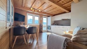 a kitchen and living room with a table and chairs at Bergquelle 1.OG Ost in Bettmeralp