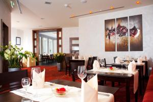 a restaurant with tables and chairs and a painting on the wall at Hotel Greive in Haren