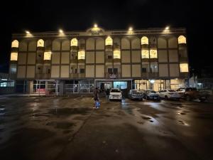 un grand bâtiment avec des voitures garées dans un parking dans l'établissement SLEEPLESS ROOM Phitsanulok, à Sathani Phitsanulok