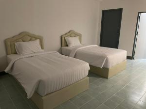 deux lits côte à côte dans une chambre dans l'établissement SLEEPLESS ROOM Phitsanulok, à Sathani Phitsanulok 4 autres photos