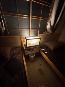 Cette petite chambre comprend deux lits et une table avec une lampe. dans l'établissement 80s stay 釧路, à Kushiro 34 autres photos