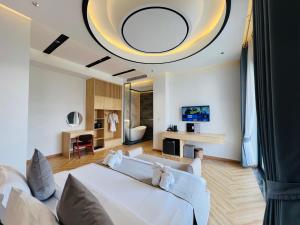 een slaapkamer met een groot wit bed en een woonkamer bij Kampot Hampton Villa in Kampot