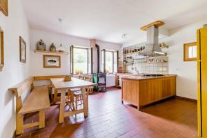 a large kitchen with a wooden table and a table sidx sidx sidx at Alla Casetta B&B in Cesiomaggiore