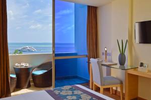 a hotel room with a desk and a view of the ocean at Season Paradise in Thulusdhoo