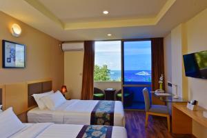 a hotel room with two beds and a view of the ocean at Season Paradise in Thulusdhoo