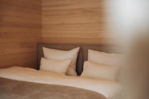 a bed with white pillows in a room at Zalbander Chalets in Silbertal