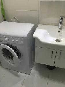 a washing machine and a sink in a bathroom at Studio Cosy MM in Tbilisi City