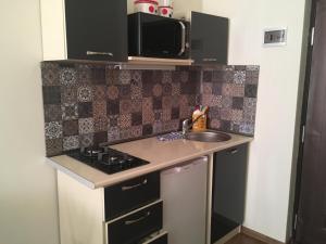 a small kitchen with a sink and a stove at Studio Cosy MM in Tbilisi City