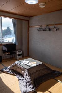 een slaapkamer met een bed in een kamer met een raam bij Bar&Lodge Duck in Gujo