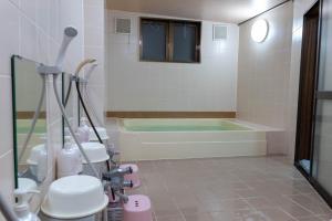 een badkamer met een bad en een douche bij Bar&Lodge Duck in Gujo