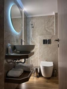 a bathroom with a sink and a toilet and a mirror at Morfeas apartments in Sarti +105 photos