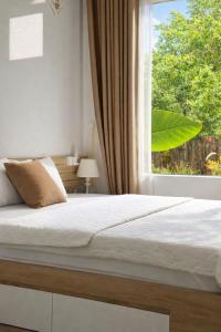 een slaapkamer met een bed en een raam bij Mộc Sơn Homestay in Mộc Châu