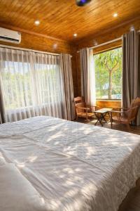 een slaapkamer met een groot bed en een groot raam bij Mộc Sơn Homestay in Mộc Châu