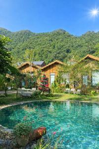 een huis met een zwembad met bergen op de achtergrond bij Mộc Sơn Homestay in Mộc Châu