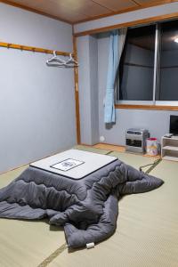 een groot bed in een kamer met een raam bij Bar&Lodge Duck in Gujo