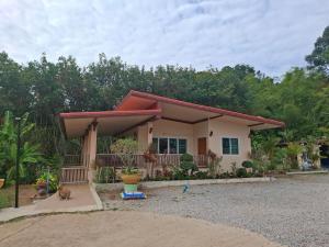 a small house with a cat sitting in front of it at Cozy Country House with Pool in Ban Nong Nam Khem