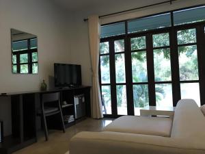 een woonkamer met een bank en een groot raam bij Doembang Villa in Ban Tha Pong