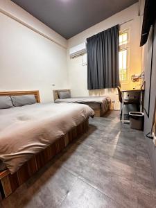 een slaapkamer met 2 bedden en een bureau bij 森林寓 Forest Inn in Minxiong