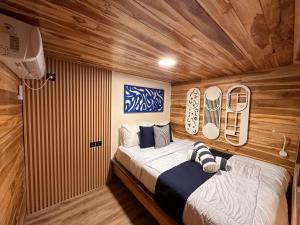 纳闽巴霍Phinisi Shared Boat Komodo的一间带床的卧室，位于一间带木墙的房间里