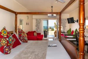 een kamer met een bed en een rode bank bij 305 Guest House in Amanzimtoti