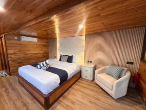 纳闽巴霍Phinisi Shared Boat Komodo的卧室里有一张床和一把椅子