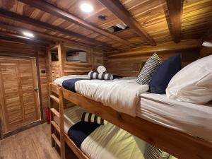 纳闽巴霍Phinisi Shared Boat Komodo的小木屋卧室内的两张双层床 更多4张照片