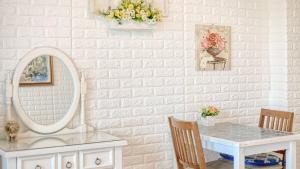 een witte kamer met een tafel en een spiegel bij Ganghwa Ara Pension in Incheon