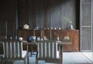 a dining room with a table and two chairs at Tsingpu Tulou Retreat 青普文化行馆 南靖土楼店 in Futian +87 photos