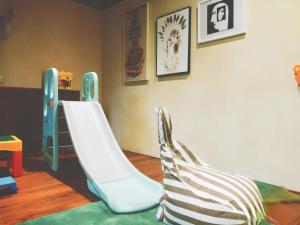 een kinderkamer met een witte glijbaan in een kamer bij Tsingpu Tulou Retreat 青普文化行馆 南靖土楼店 in Nanjing