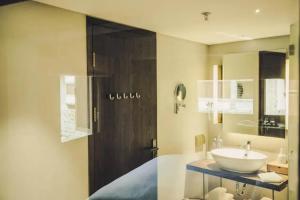 een badkamer met een wastafel en een aanrecht met een spiegel bij Tsingpu Tulou Retreat 青普文化行馆 南靖土楼店 in Nanjing +83 foto's