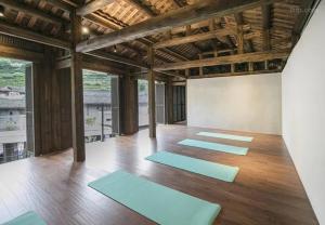 een kamer met een rij blauwe yogamatten bij Tsingpu Tulou Retreat 青普文化行馆 南靖土楼店 in Nanjing