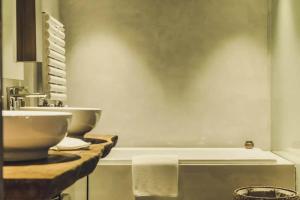 a bathroom with a sink and a bath tub at Tsingpu Tulou Retreat 青普文化行馆 南靖土楼店 in Futian