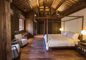 a bedroom with a bed with a metal canopy at Tsingpu Tulou Retreat 青普文化行馆 南靖土楼店 in Futian