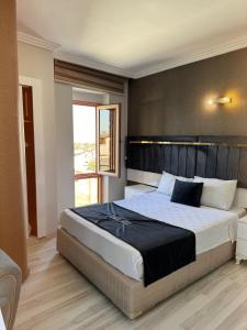 une chambre avec un grand lit et une fenêtre dans l'établissement Yilmazel Hotel, à Gaziantep