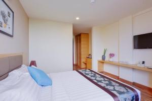 a bedroom with a bed with a tv on the wall at Season Paradise in Thulusdhoo
