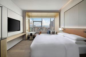 een hotelkamer met een groot bed en een flatscreen-tv bij Courtyard by Marriott Luoyang in Luoyang +32 foto's
