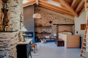 Habitación con pared de piedra, mesa y sillas. en Espectacular Chalet de Montaña Pirineos, Burg, en Burg