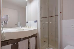 een badkamer met een wastafel en een douche bij Ace Hotel Bourges in Bourges