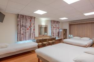 een hotelkamer met twee bedden en een bureau bij Ace Hotel Bourges in Bourges