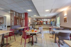 een eetkamer met tafels en stoelen in een restaurant bij Ace Hotel Bourges in Bourges +3 foto's