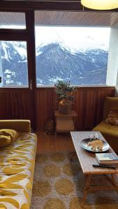een woonkamer met een tafel en uitzicht op een berg bij DUPLEX Les Plautus in Orcières