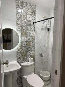 a white bathroom with a toilet and a sink at Daniel's Comfort Studio in Hipusñgo
