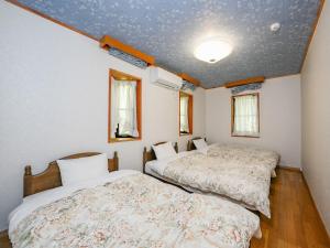 twee bedden in een kamer met witte muren bij Runesu Karuizawa - Vacation STAY 78428v in Tsumagoi