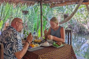 a man and a woman sitting at a table eating food at Nary Garden in Kampot