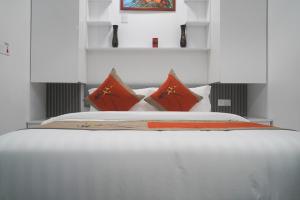 een slaapkamer met een wit bed met rode kussens bij LemonRock Comfort in Male City +56 foto's