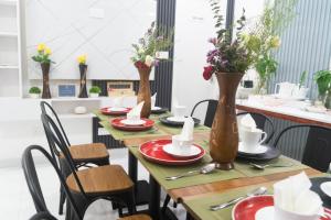 een lange tafel met bloemen in vazen erop bij LemonRock Comfort in Male City