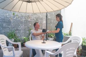 een man en een vrouw aan een tafel onder een paraplu bij LemonRock Comfort in Male City