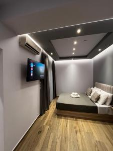 a room with a bed and a tv on a wall at Morfeas apartments in Sarti